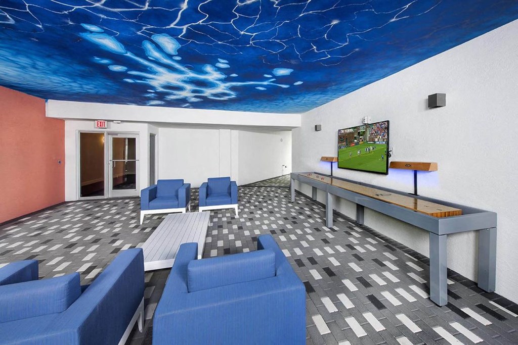 a lobby with blue couches and a tv