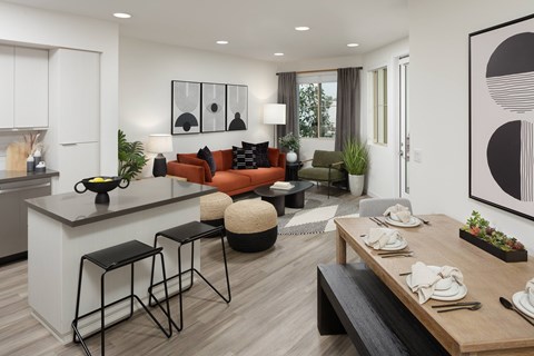 A modern kitchen with a bar and a dining table set for two.