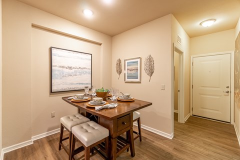 A dining room with a wooden table and chairs.