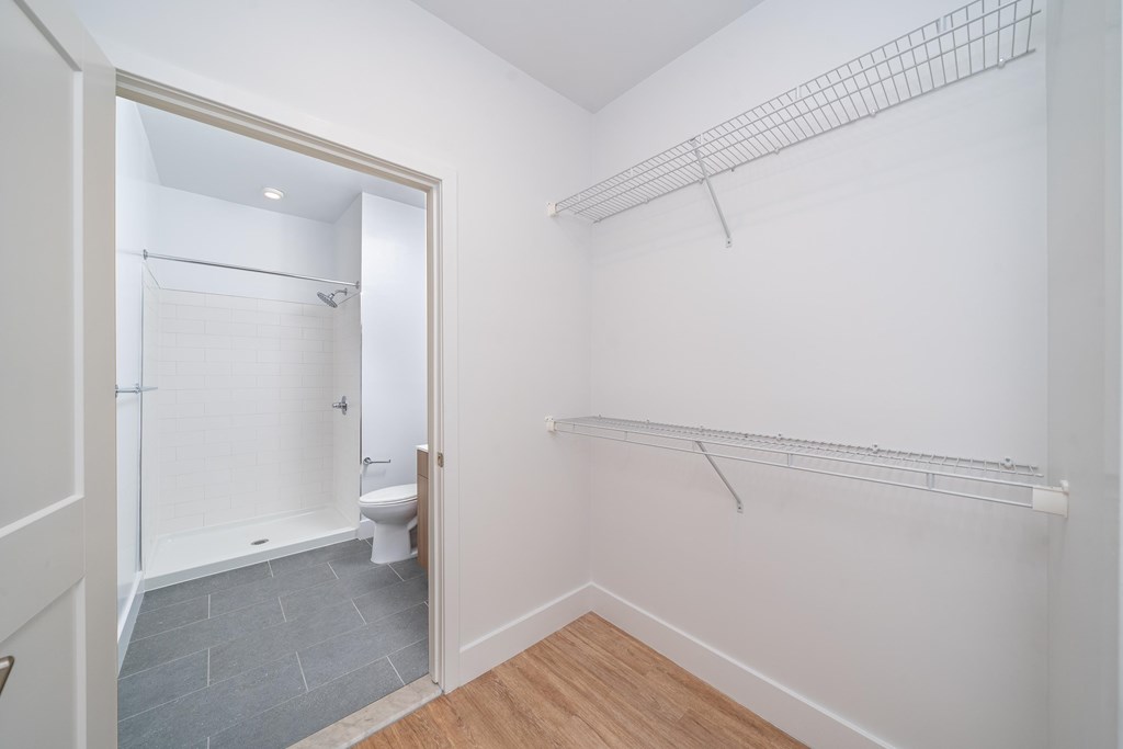 A white bathroom with a walk in shower and a toilet.