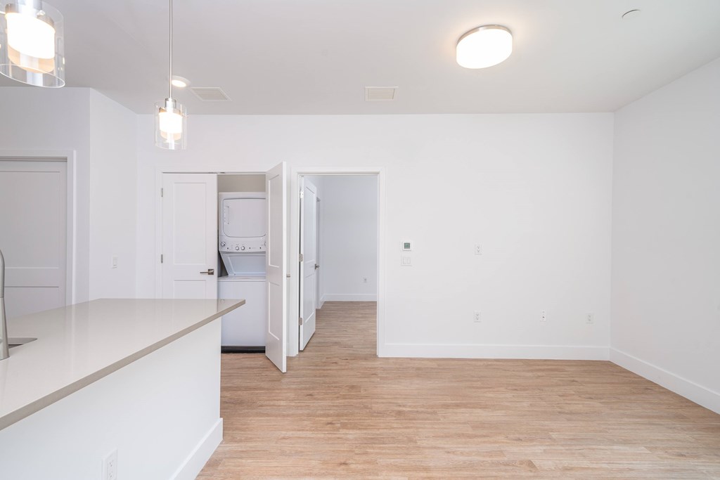 A kitchen with white cabinets and a wooden floor.