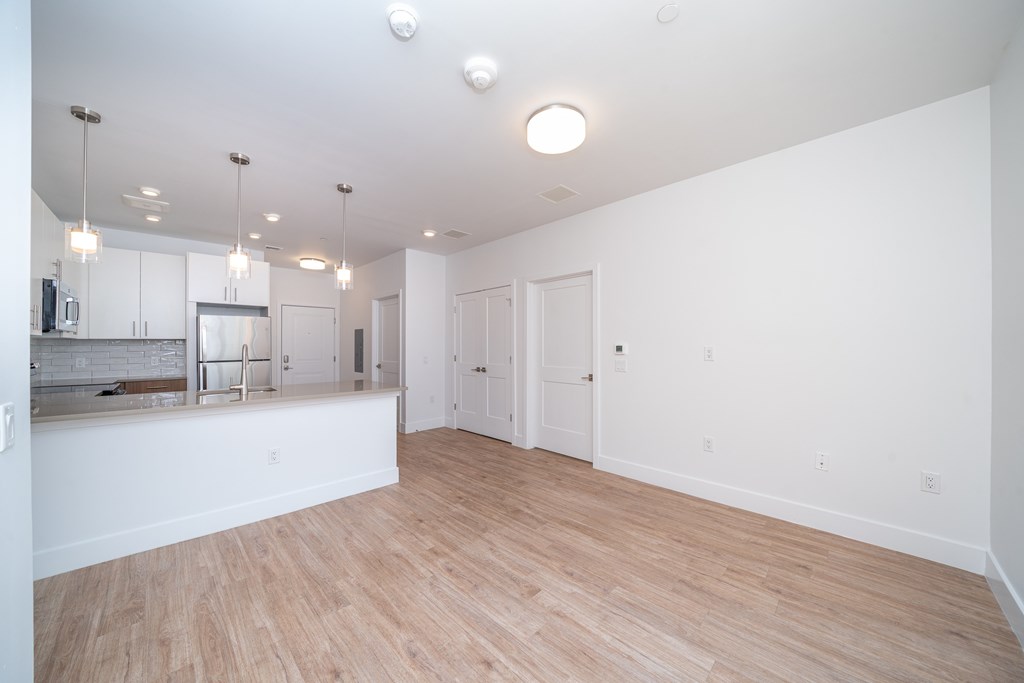 A large empty room with wooden floors and white walls.