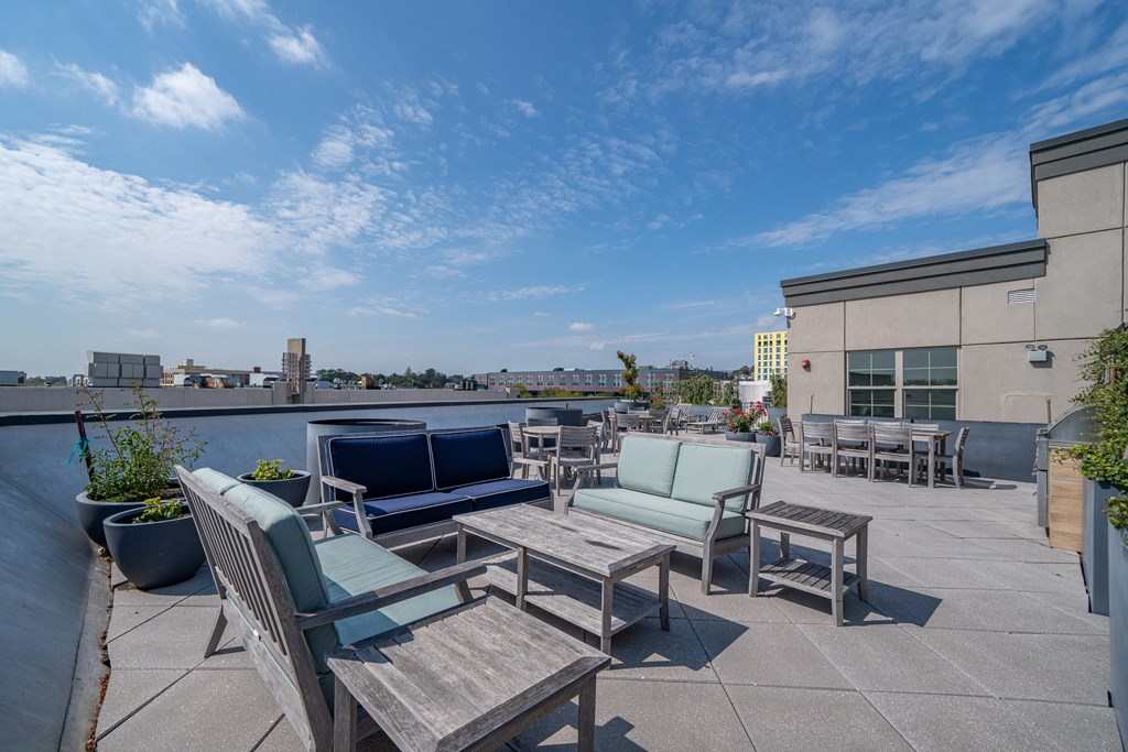 A patio with a table and chairs overlooking a city skyline.