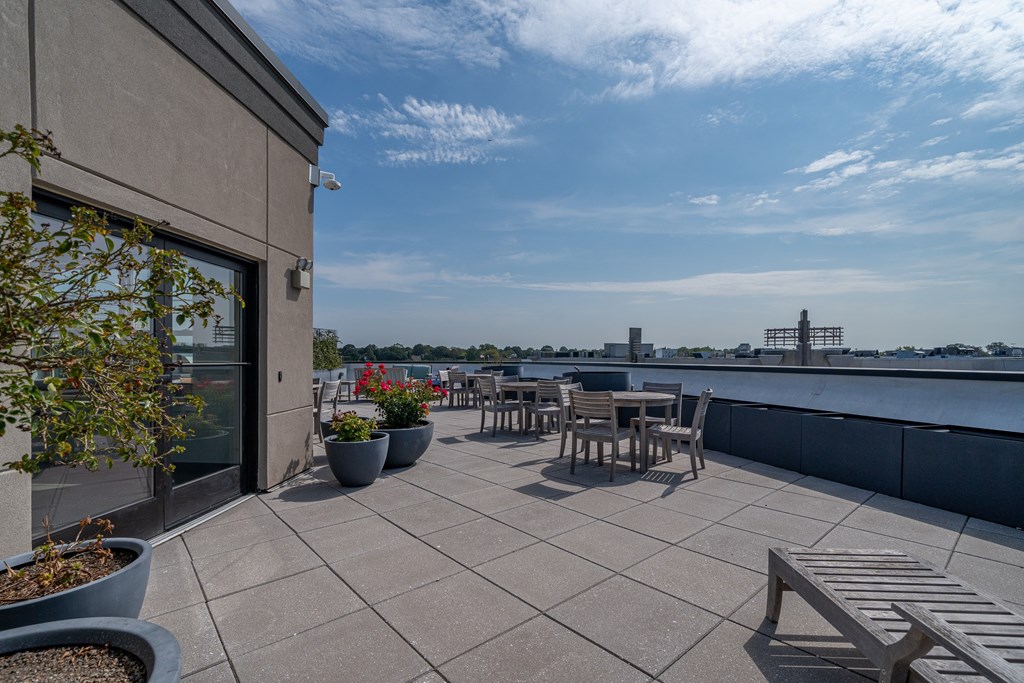 A patio with a table and chairs overlooking a body of water.