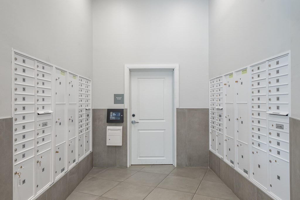 A white door is flanked by two walls of lockers.