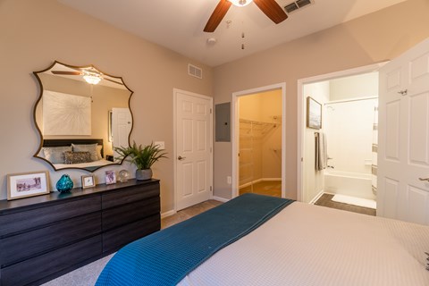 A bedroom with a large bed and a mirror on the wall.