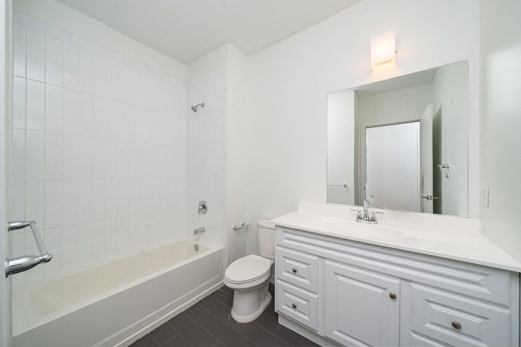 a white bathroom with a toilet and a tub and a sink