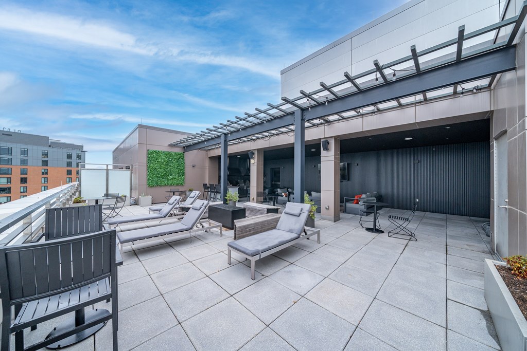 A rooftop patio with a table and chairs.