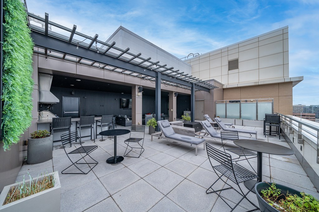 A patio with a table and chairs is surrounded by a building.