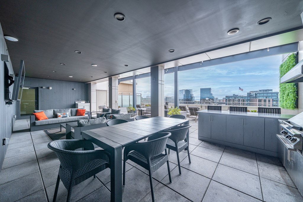 A modern outdoor dining area with a table and chairs.