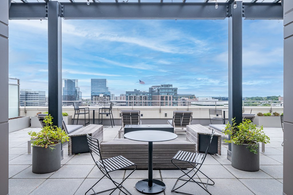 A patio with a table and chairs overlooking a city skyline.