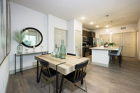 A dining room with a wooden table and chairs.