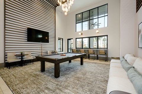 A living room with a pool table and a television.