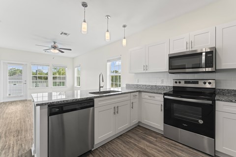 A kitchen with a stainless steel dishwasher and oven, and a microwave above the stove.