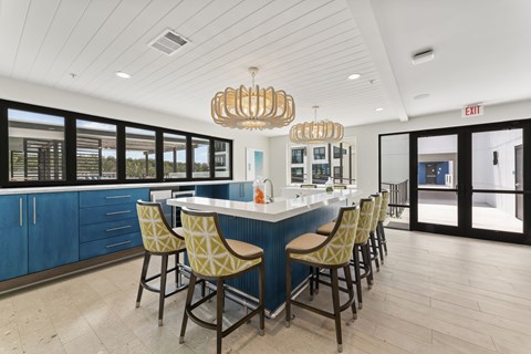 A kitchen with a bar area and chairs.