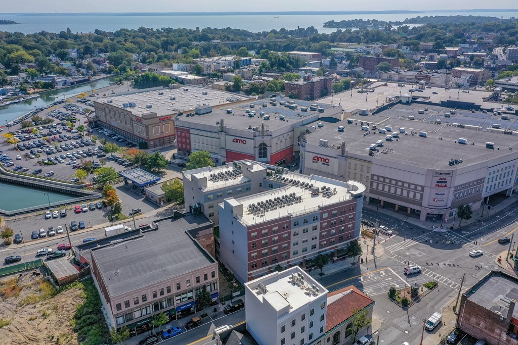A cityscape with a large building in the center and a parking lot in the foreground.