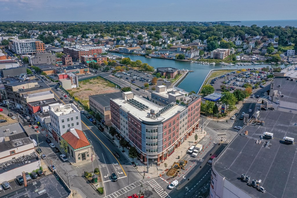 A cityscape with a large building in the center and a body of water in the background.