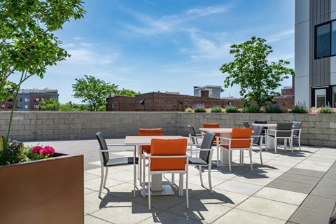 A patio with orange chairs and a table.
