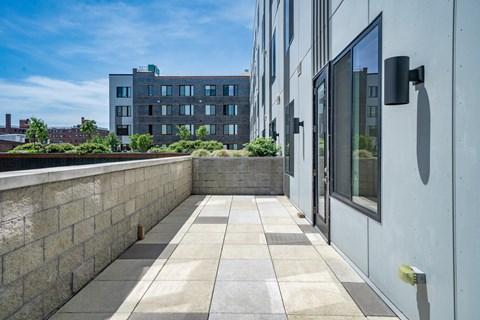 A modern building with a stone wall and glass doors.