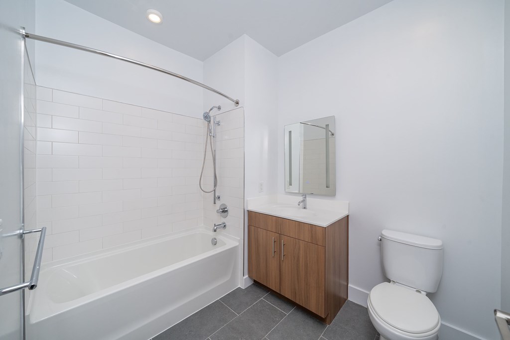 A white bathroom with a toilet, sink, and bathtub.