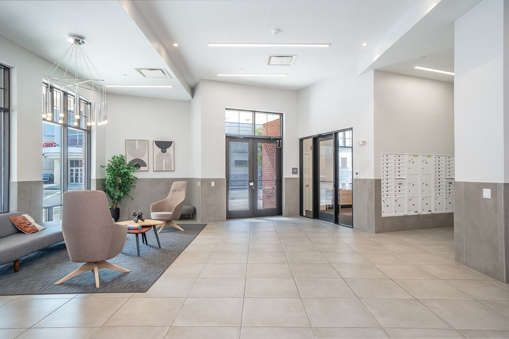 A modern waiting room with a couch, chairs, and a plant.