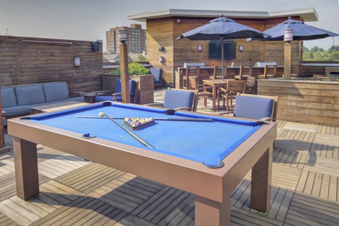 Rooftop terrace with pool table and outdoor dining at 163 Franklin Street Apartments, Stamford