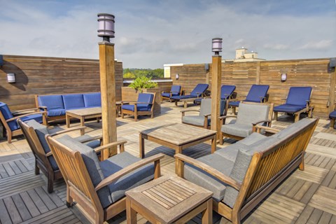Rooftop lounge with wooden furniture and privacy panels at 163 Franklin Street Apartments, Connecticut