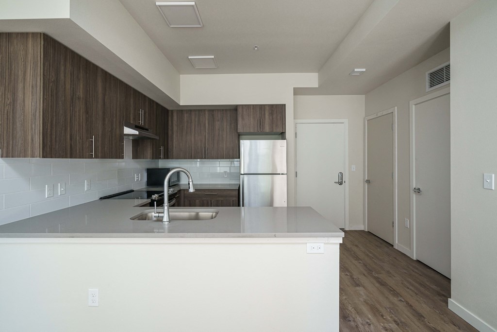 an empty kitchen with a sink and a refrigerator