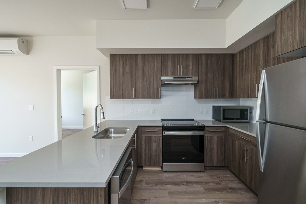 an empty kitchen with wooden cabinets and stainless steel appliances