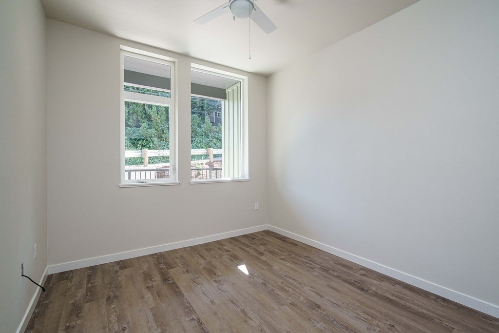 an empty room with wood floors and a window