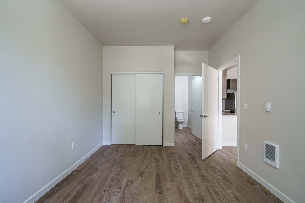 an empty living room with white walls and wood flooring