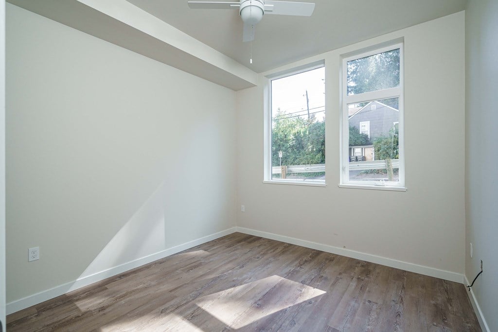 an empty room with hardwood floors and a window