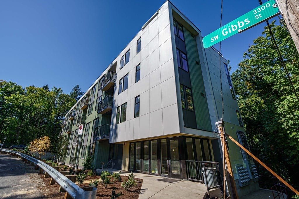 a green and white building with a street sign in front of it