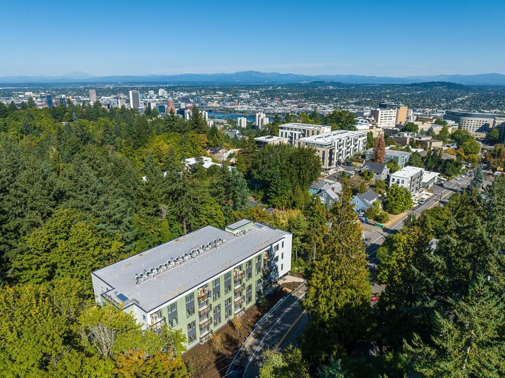 an aerial view of a building surrounded by trees and a city