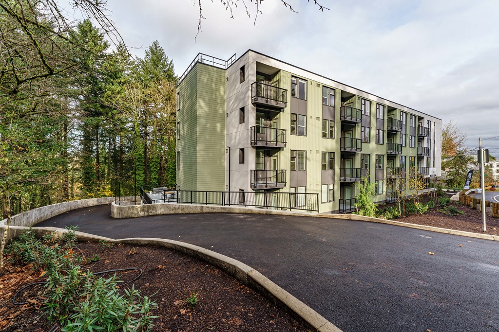 the exterior of a building with a parking lot and trees