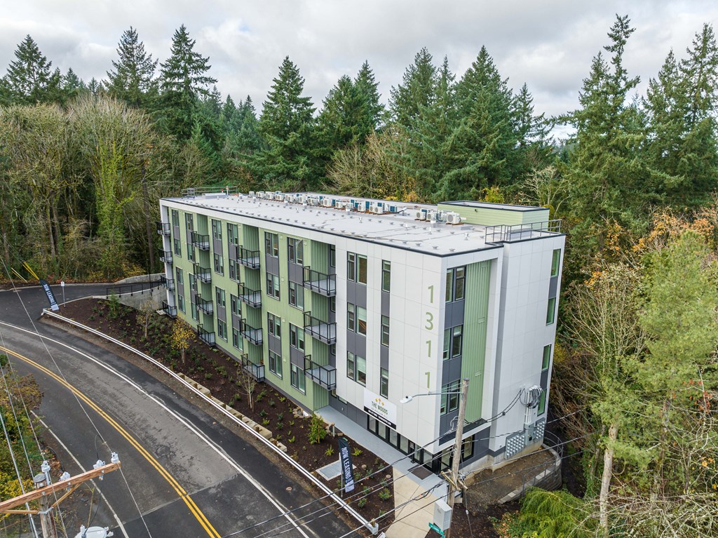 an aerial view of an apartment building on the side of a road