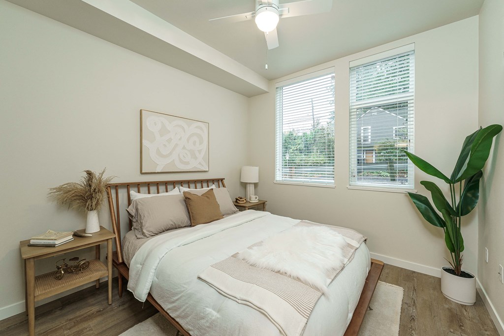 a bedroom with a bed and two windows