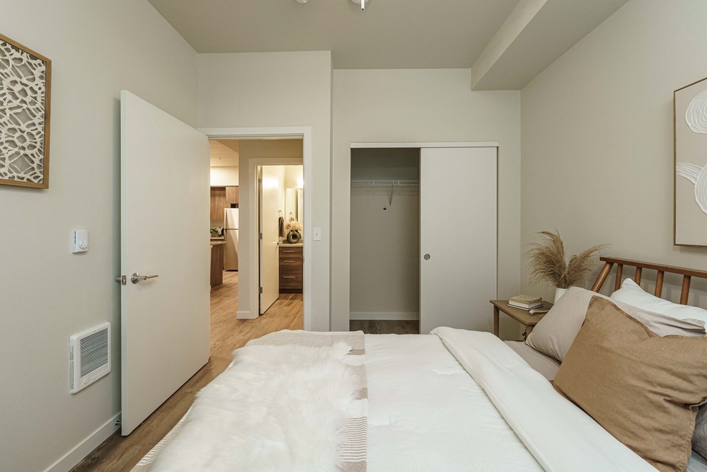 a bedroom with a large white bed and a door to a bathroom