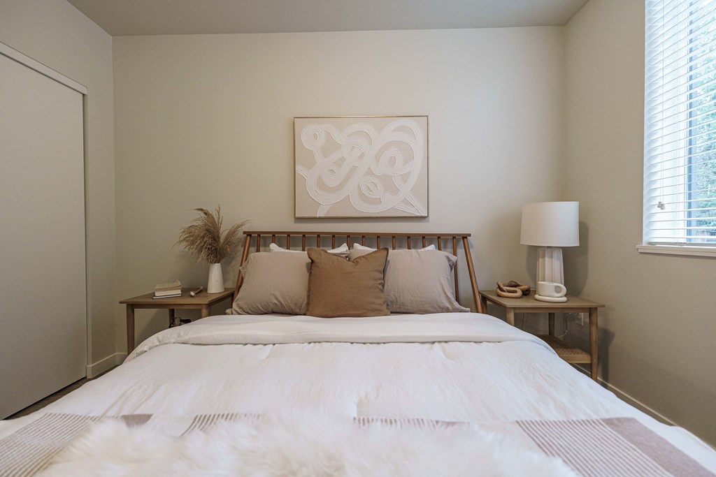 a bedroom with a bed and a painting on the wall