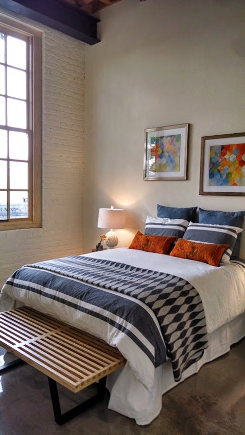 a bedroom with a bed and some pictures on the wall