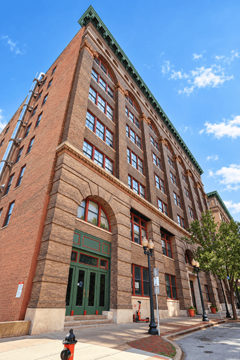 A red brick building with green trim and a green door.