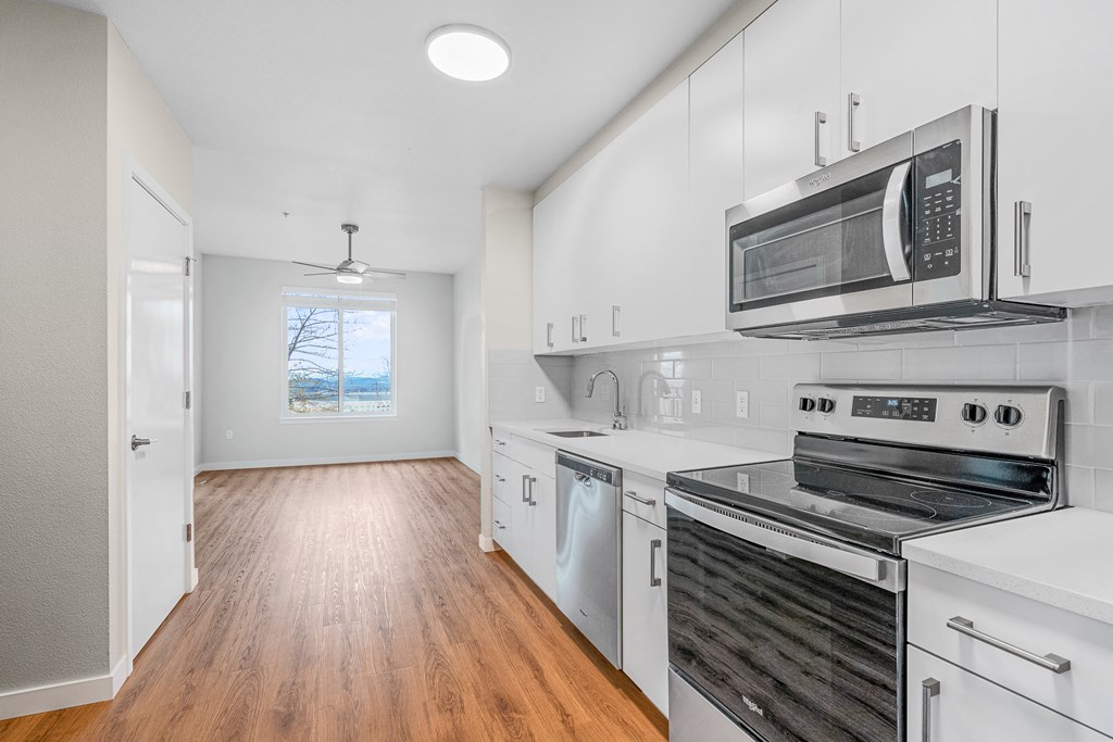 a kitchen with white cabinetry and stainless steel appliances
