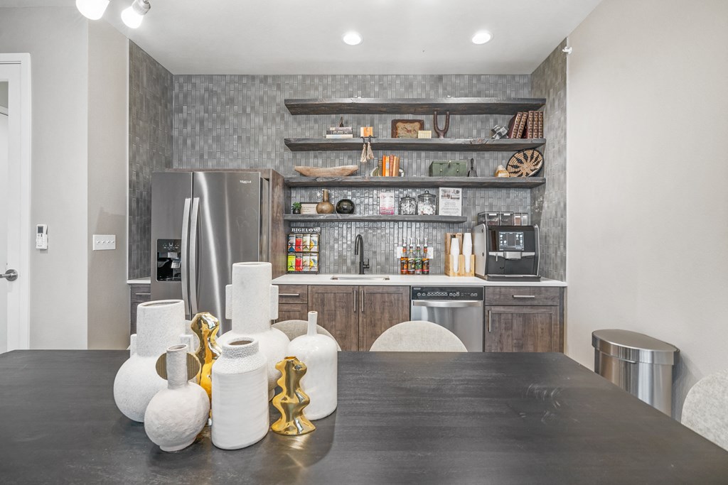 a kitchen with a large black table and stainless steel appliances