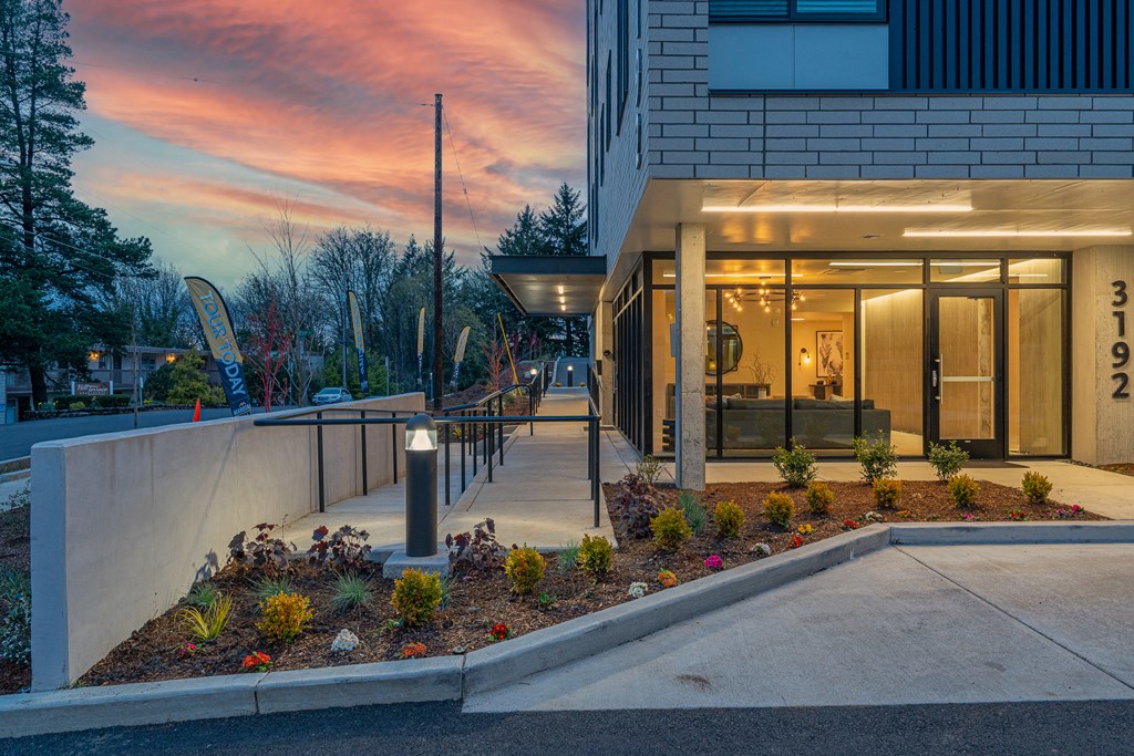 a view of the front entrance of a building with a sunset in the background
