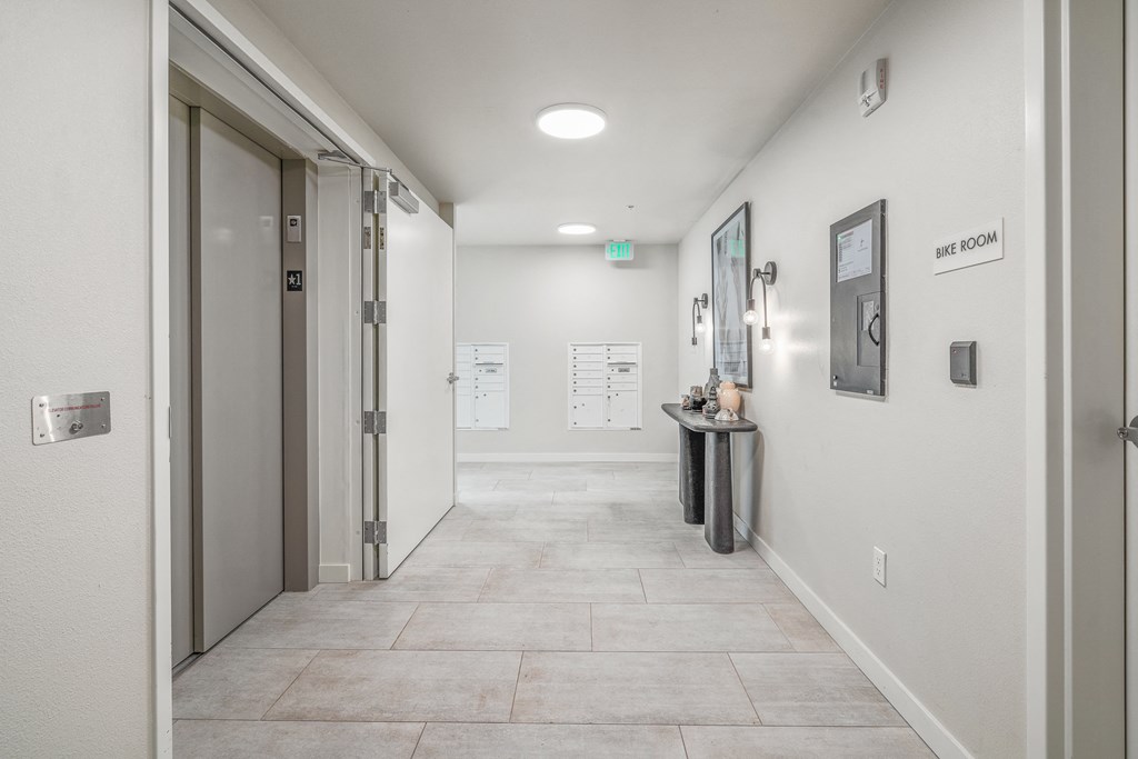 a hallway with a door at the end and a counter on the side of the hallway