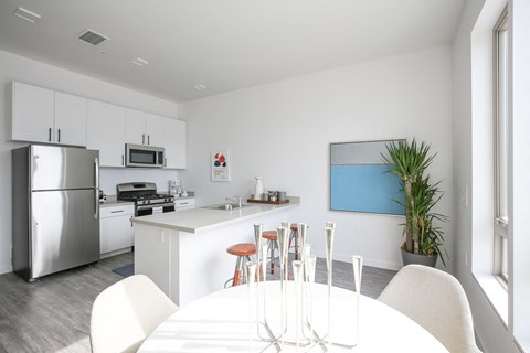 a kitchen and dining room with a white table and chairs