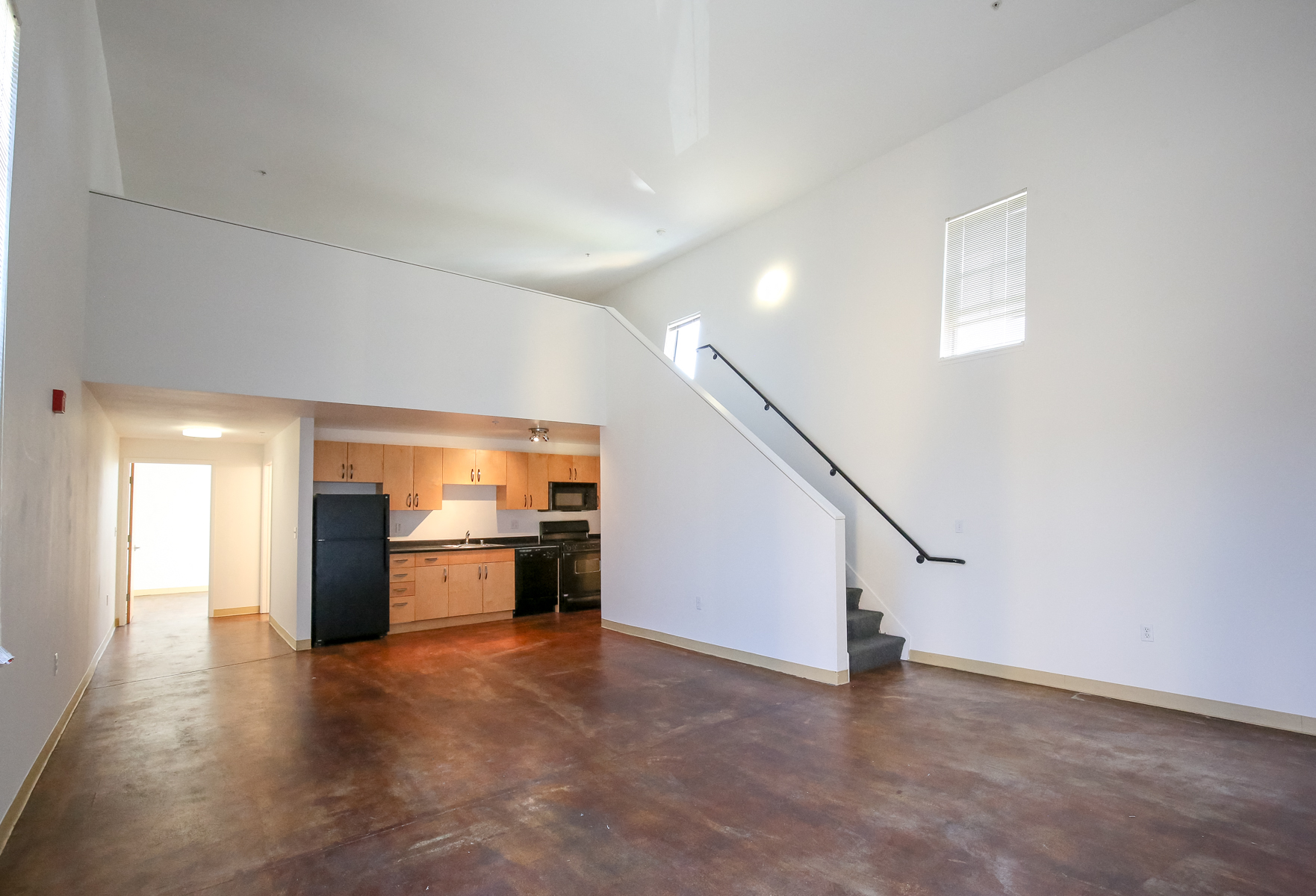 View of B2 living, kitchen and loft space unstaged