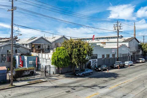 A street view with cars parked on the side of the road and buildings in the background.