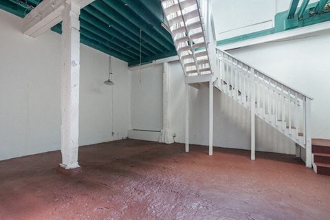 A room with a white staircase and a green roof.