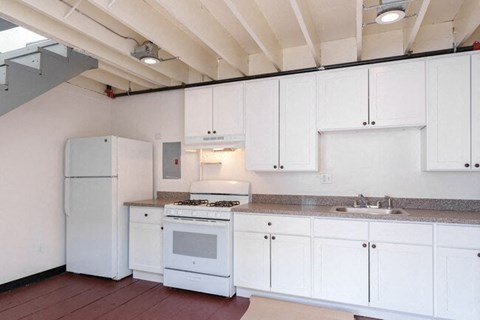 A kitchen with white cabinets and appliances.